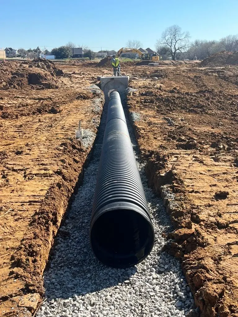 Large HDPE storm drain line set on rock bedding in a residential development