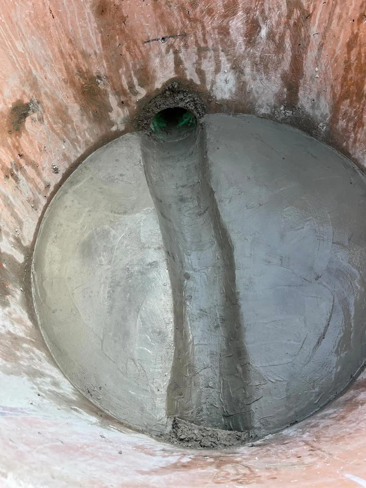 Finished concrete invert channel inside a sanitary sewer manhole